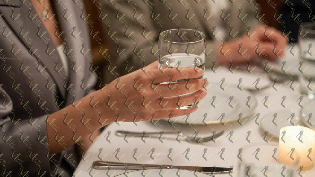 Рука с подносом воды у столов на деловом ужине в Москве — без слов, без спешки.