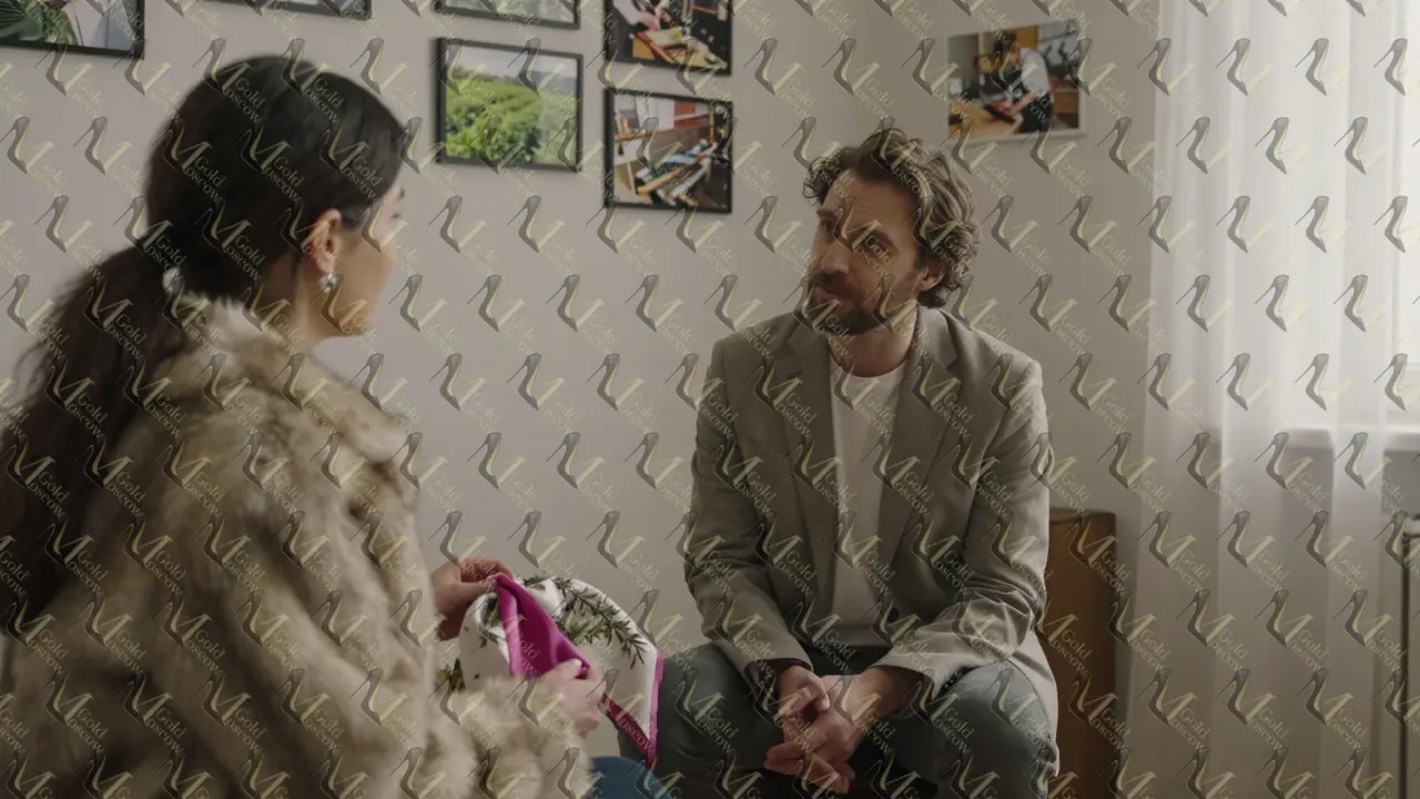 Консультант и клиент в спокойной обстановке обсуждают шелковый шарф с пигментами из розмарина.